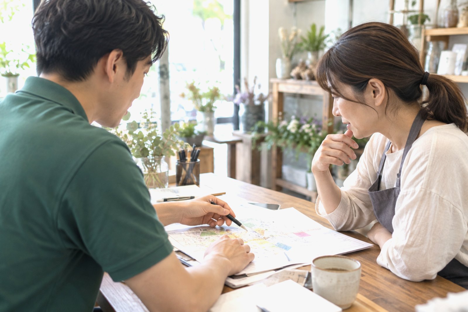 店舗のオーナーと地図を見ながら配布エリアを相談する様子